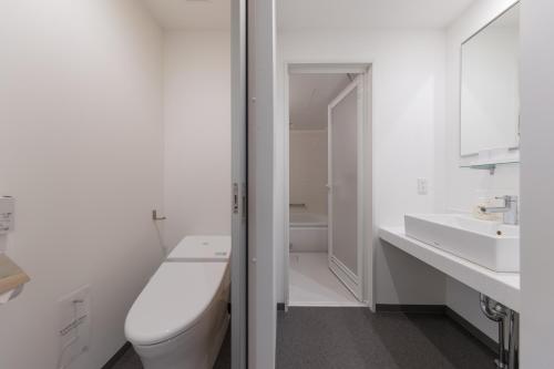 宫崎JR九州宫崎酒店的白色的浴室设有卫生间和水槽。