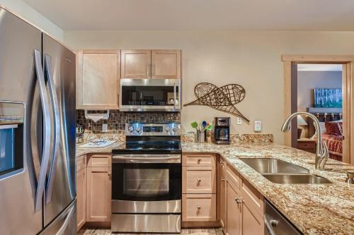 铜山Copper Springs 320 condo的厨房配有不锈钢冰箱和水槽