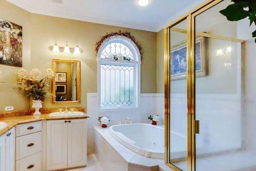 波茨敦Luxury Vacation Estate的一间带浴缸和淋浴的浴室以及窗户。