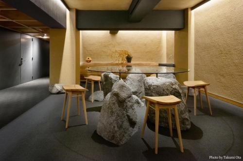 奈良MIROKU NARA by THE SHARE HOTELS的配有桌子、椅子和桌子的房间