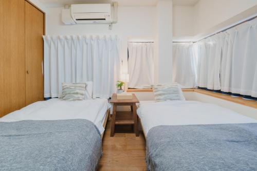 挂川市White Space的客房设有两张床和一张带窗户的桌子。