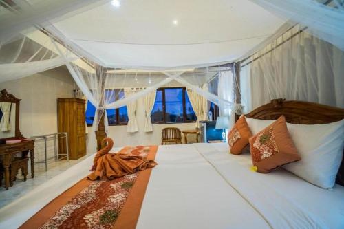 乌布Bangbang Guest House Ubud的一间卧室设有一张大床和大窗户