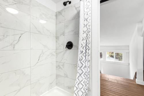 底特律Stately Studio Apartment的一间设有白色大理石墙壁和淋浴的浴室