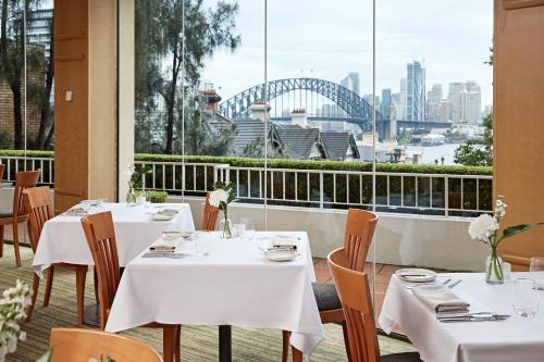 悉尼View Sydney的一间带桌椅的餐厅,享有悉尼海港的景致