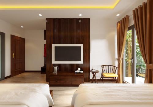 宁平Tamcoc Catalina Hotel的一间卧室配有两张床和一台平面电视