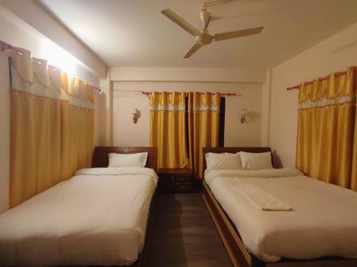索拉哈Hotel Town View的配有黄色窗帘的客房内的两张床