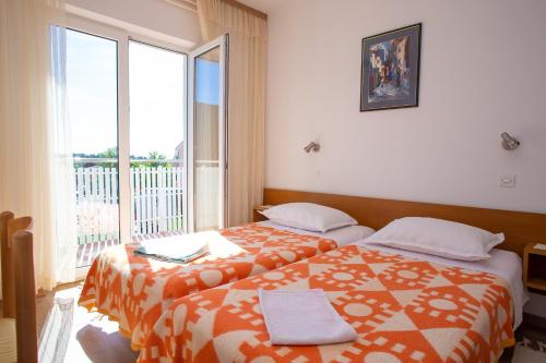 诺瓦利娅Apartments and rooms Ivan - great location的一间卧室设有两张床和大窗户