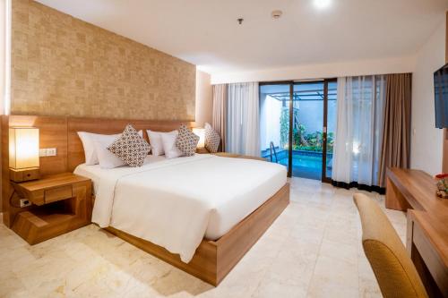 库塔Cross Vibe Paasha Atelier Bali Kuta的一间卧室设有一张大床和一个大窗户