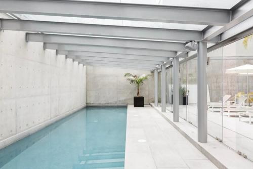 墨西哥城Departamento mexicano en Polanco. Pool - gym - parking的一座蓝色海水室内游泳池,位于一座建筑中