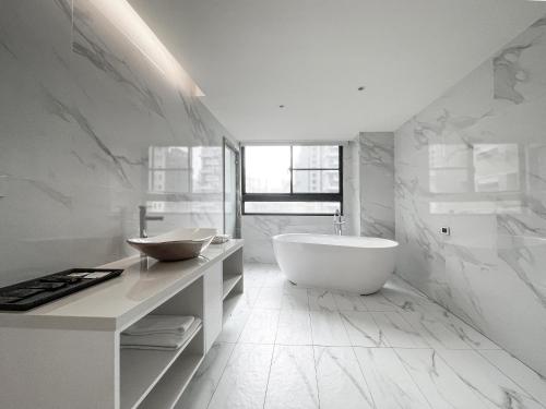 台中市雀客旅馆台中青海的白色的浴室设有浴缸和水槽。