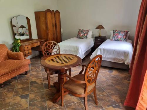 DalmadaPecan Nut Place的一间设有两张床、一张桌子和一把椅子的房间