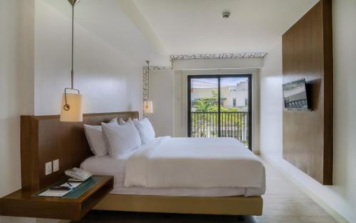 大雅台Quest Hotel Tagaytay的酒店客房设有一张床和一个阳台。