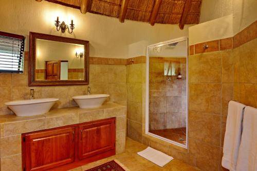 Kaingo Private Game ReserveRoyal Morubisi Founder's Lodge的一间带两个盥洗盆和淋浴的浴室
