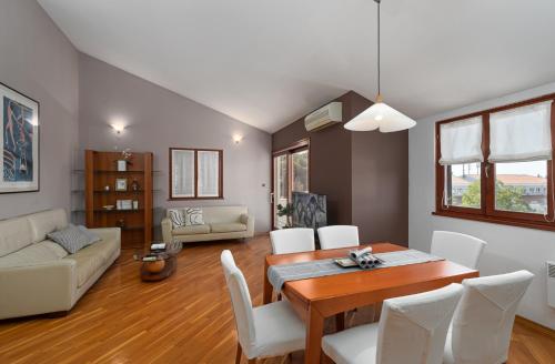 波雷奇Biba Lux的客厅配有木桌和白色椅子