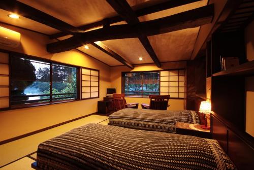 宫津市天桥立对桥楼酒店的带2扇窗户的客房内的2张床