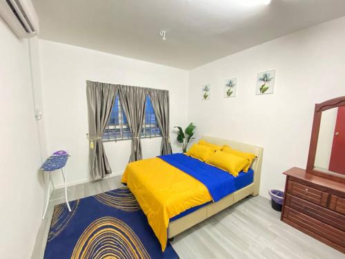瓜拉丁加奴Homestay Kuala Terengganu Affan01 Dekat Pantai Batu Buruk的一间卧室配有黄色和蓝色的床和镜子
