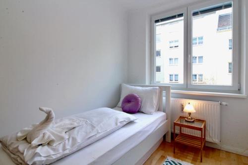 维也纳Central Vienna Charm - Comfortable 3-BR Stay的白色卧室配有带紫色枕头的床