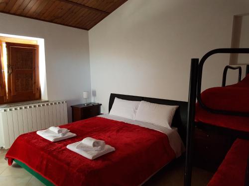 Masseria di RuscianoQUERCIA ANTICA的一间卧室配有一张床,上面有两条毛巾
