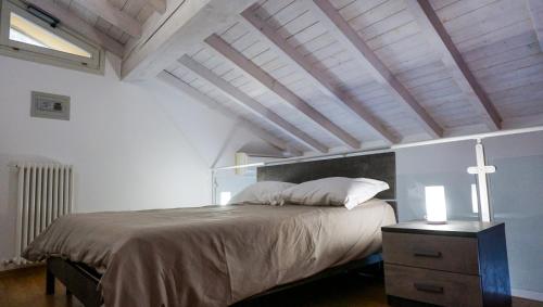 曼托瓦Residenze Umberto I的一间卧室设有一张大床和木制天花板