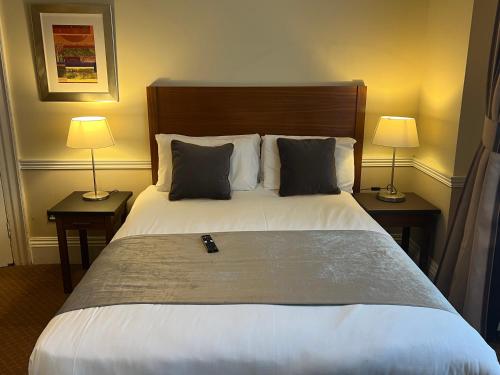 伦敦卡文迪什酒店的一间卧室配有一张大床和两盏灯