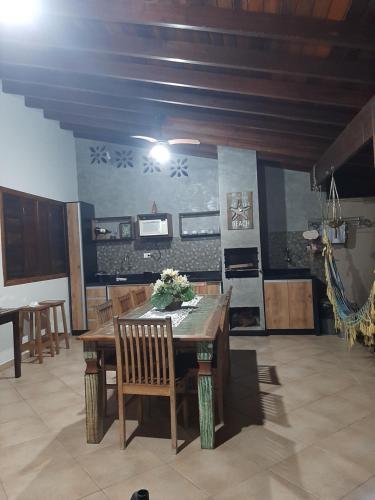 乌巴图巴Suítes Canola的一间带木桌和椅子的用餐室