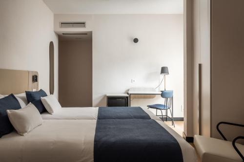萨拉戈萨多恩海姆54号酒店的配有一张床和一张书桌的酒店客房