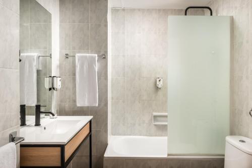 萨拉戈萨多恩海姆54号酒店的浴室配有白色水槽和淋浴。