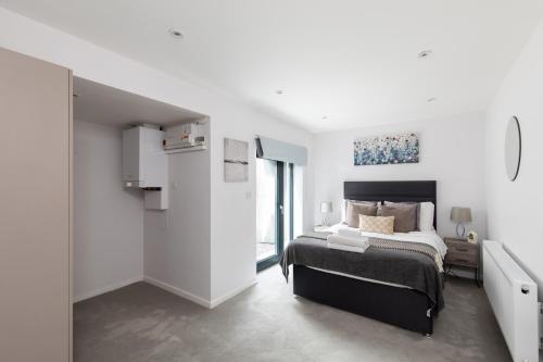 伦敦homely - Central London Camden Town Apartments的白色的卧室设有床和窗户