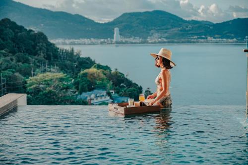 芭东海滩Wyndham Grand Phuket Kalim Bay的坐在水中的女人
