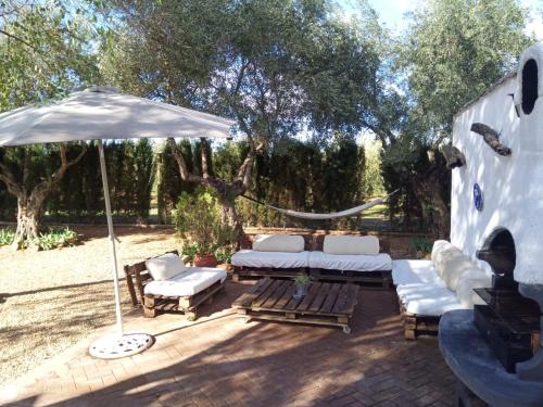 马尔莫莱霍La Casa del Abuelo Jose的庭院配有白色的沙发和遮阳伞。