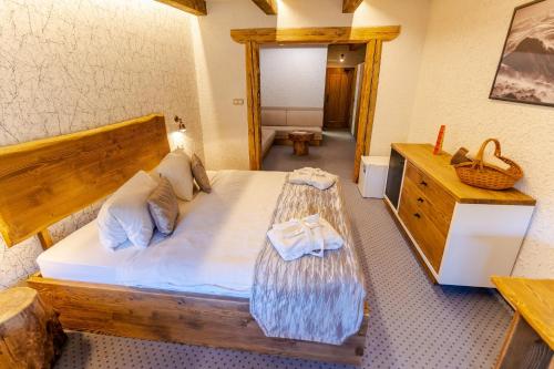 利托斯基简斯特拉尚夫卡让斯卡考利巴酒店的一间卧室配有一张大型木床和一个梳妆台。