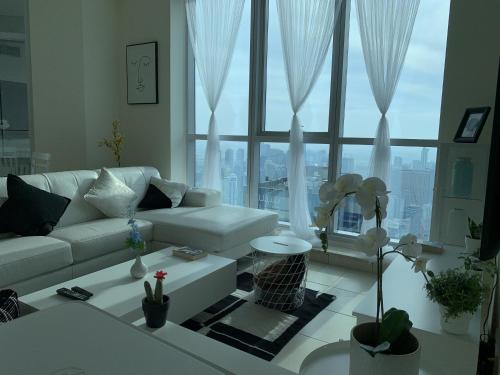 迪拜Torch 77的客厅配有白色沙发和大窗户