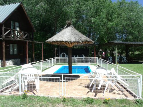 吉亚迪诺镇Del Carmen的一座房子旁的游泳池,配有遮阳伞和椅子