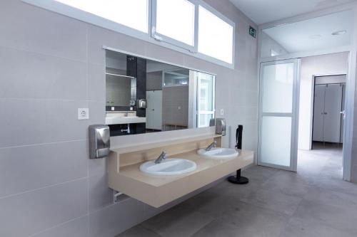 埃斯库约斯圣何塞埃斯库约斯旅游酒店的一间带两个盥洗盆和大镜子的浴室
