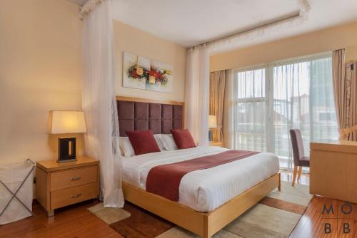 内罗毕Lenana Suites的一间卧室设有一张大床和一个窗户。