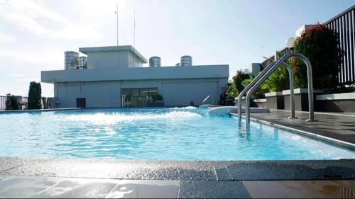 SunggalSkyview Premier Suites Hozby的大楼前的大型游泳池