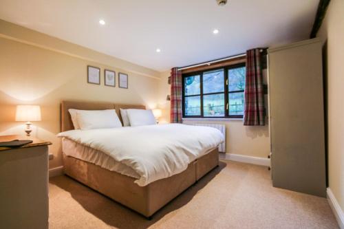 比尔斯韦尔斯Kestrel Cottage的一间卧室设有一张大床和一个窗户。