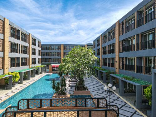 华欣Golden Sea Hua Hin - SHA Extra Plus的一座带游泳池的公寓大楼的空庭院