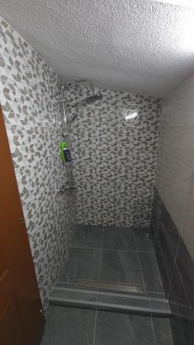 ŠipovoPlaninske kolibe Šipovo的一间带淋浴的浴室和瓷砖墙