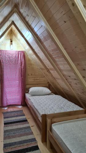 ŠipovoPlaninske kolibe Šipovo的一间小型阁楼卧室,配有一张床和地毯