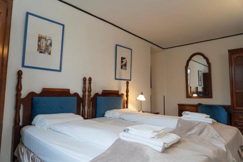 柏林Hotel Petit Wannsee的卧室配有两张单人床和镜子