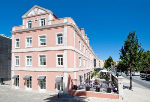 卡尔达斯达·赖尼亚萨那银海岸酒店的粉红色的建筑,上面有一个钟楼