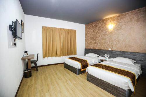 小笨珍New Dawn Hotel Pontian Sdn Bhd的酒店客房设有两张床和窗户。