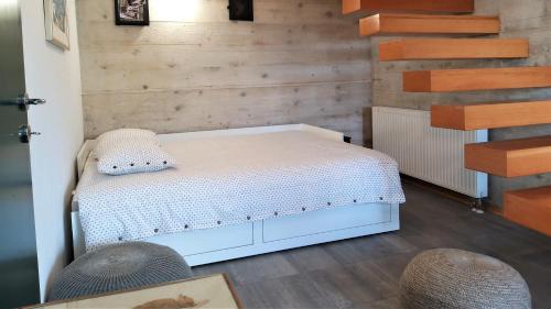 科雷尼察Villa Bornstein的卧室设有白色的床和木墙