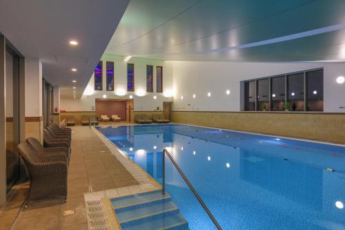 克鲁Crewe Hall Hotel & Spa - Cheshire的一个带椅子的大型游泳池