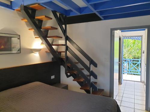 拉萨尔勒班水族海滩酒店的一间卧室设有螺旋楼梯和蓝色天花板