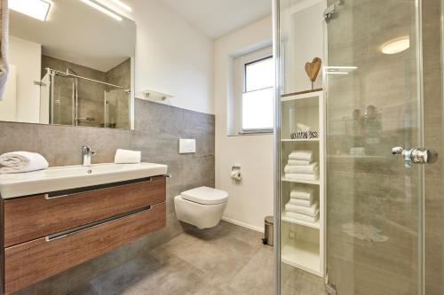 加尔米施-帕滕基兴BergZeit的浴室配有卫生间、盥洗盆和淋浴。