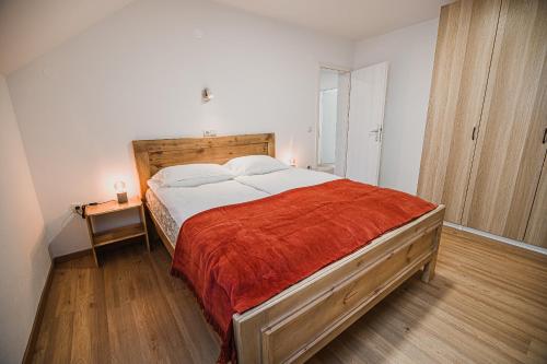 克拉尼Mojčin Pisker Apartment House的一间卧室配有一张带红色毯子的大床