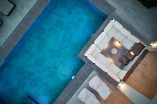 基普塞利Villa Belen的享有带白色家具的游泳池的上方景致