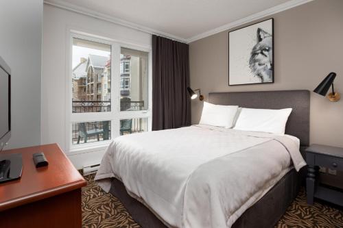 蒙特朗布朗御峰园德内格斯酒店的一间卧室配有一张床、一张书桌和一个窗户。